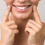 closeup view of female wide cheerful smile with white teeth and clean skin.