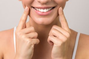 closeup view of female wide cheerful smile with white teeth and clean skin.