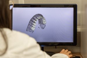 Woman working on computer with dental software platform