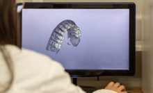 Woman working on computer with dental software platform