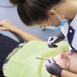 Dental treatment at the dental clinic, female doctor treating patient.