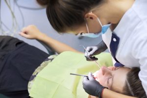 Dental treatment at the dental clinic, female doctor treating patient.