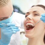 Dentist examining patient's teeth in clinic