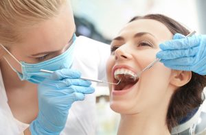 Dentist examining patient's teeth in clinic