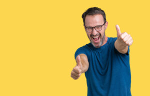 Handsome middle age hoary senior man wearin glasses over isolated background approving doing positive gesture with hand, thumbs up smiling and happy for success. Looking at the camera, winner gesture.