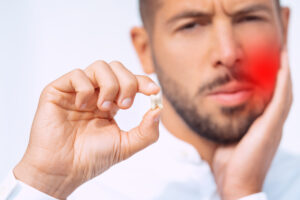 Man feeling pain after tooth extraction or tooth removal surgery. High quality photo