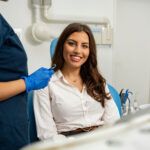 Satisfied patient sitting in dentist chair. Gorgeous young woman