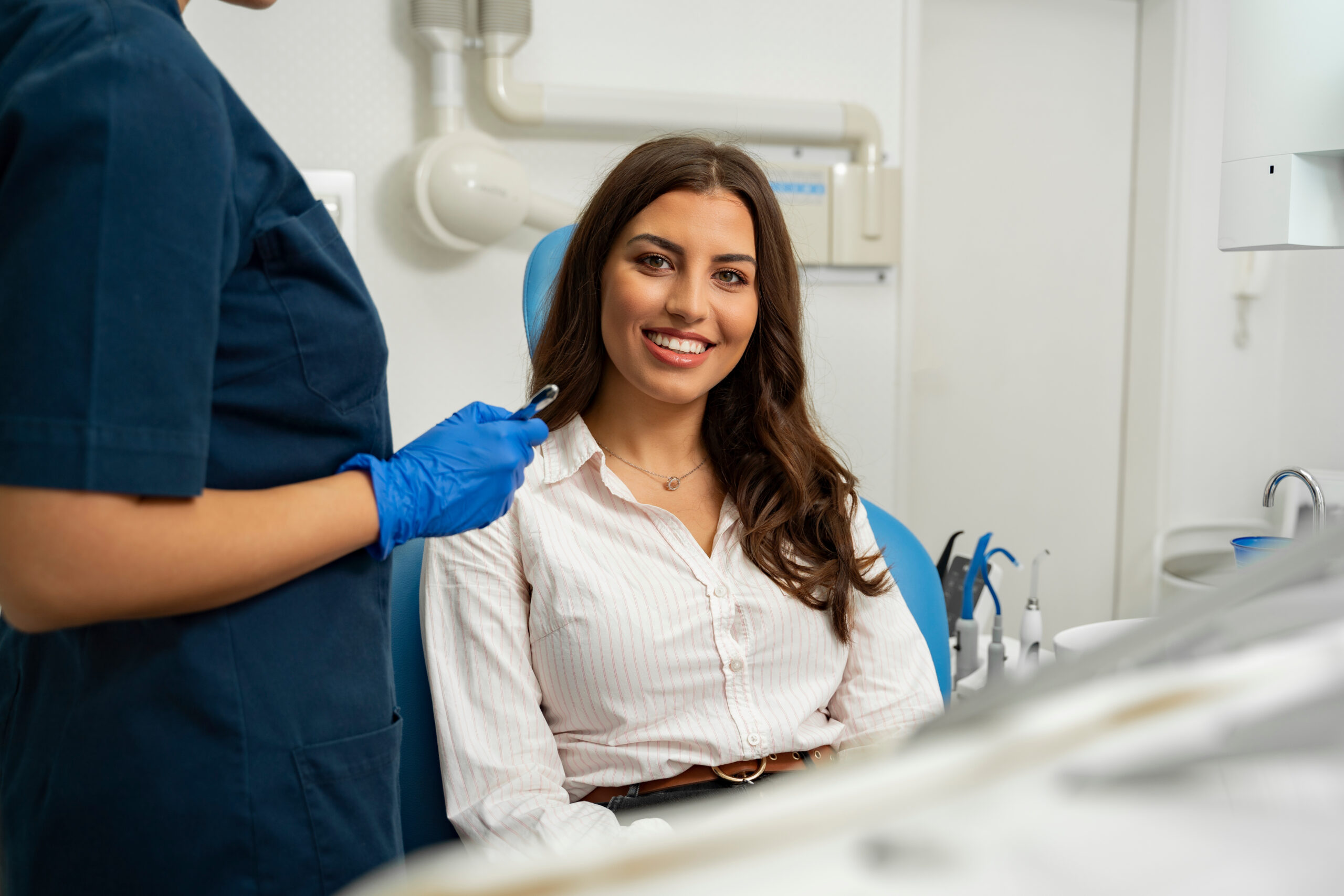 Satisfied patient sitting in dentist chair. Gorgeous young woman
